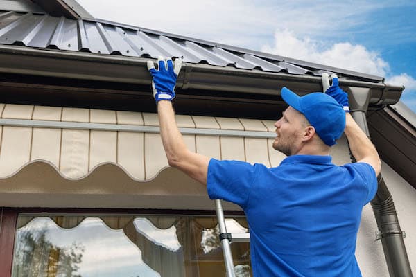 roofing pros contractor installing house roof rain gutter system by roofing pros the best roofers in castle rock colorado